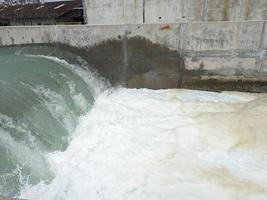 Texture and surface of seawater fall on the power plant with foaming on the outfall. The photo is suitable to use for industry background, environment poster and nature content.