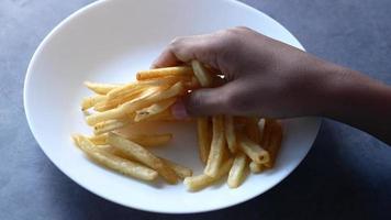 garçon main choisir français frites de une assiette sur table video