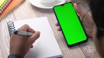 Top view of man hand using smart phone on office desk. video