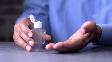 young man in blue shirt using hand sanitizer gel video