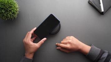 smartphone in carica tramite pad di ricarica wireless, vista dall'alto video