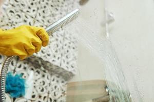 Woman cleaning bathroom cabine photo