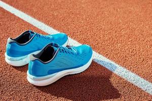 Blue running sneakers at stadium track photo