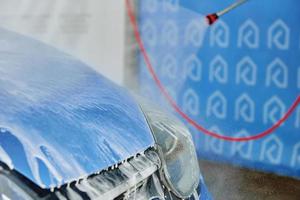 Cleaning car with high pressure water at car wash station photo