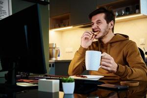 Tired man works late at workplace, use computer photo