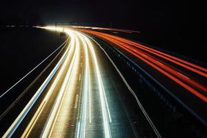Moviente coche luces en autopista a noche, largo exposición foto