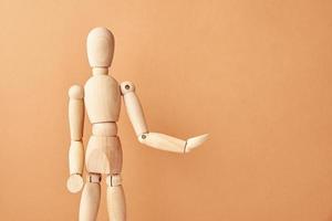 Wooden doll on beige background photo