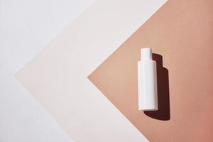 Natural cosmetic product. White bottle on pastel background photo