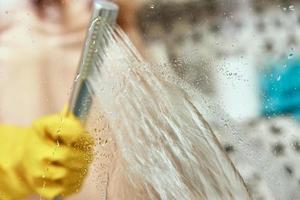 Woman cleaning bathroom cabine photo