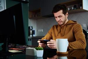 Man play game on smartphone while working at home warkplace photo