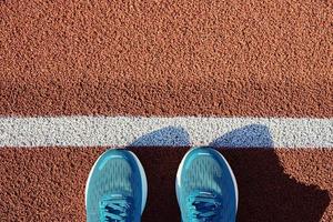 Blue running sneakers at stadium track photo