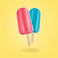 Two color popsicles on yellow background photo