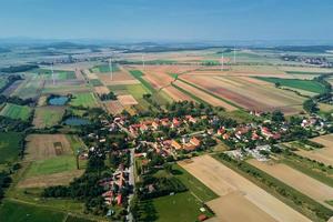 Small village near wind turbine generator, aerial view photo