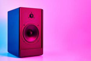 Stereo sound speaker on neon colored background photo