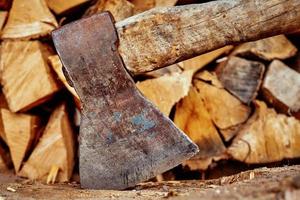 Close up of axe agains firewood background photo