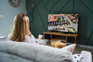 Woman switch channels on TV set with remote control. photo