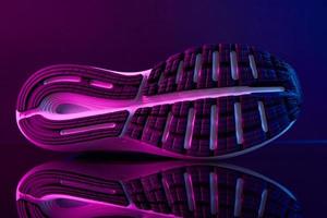 Close up sole of sport shoe in neon colored background photo