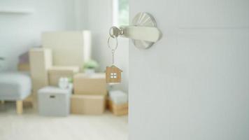 Moving house, relocation. The key was inserted into the door of the new house, inside the room was a cardboard box containing personal belongings and furniture. move in the apartment or condominium video