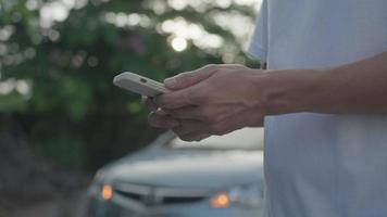 panne, voiture cassée, réparation. l'homme utilise les primes d'assurance de vérification de téléphone portable via une application en raison d'un accident de voiture. trouver un garage pour réparer la voiture pendant la visite du pays, attendre de l'aide, urgence. video