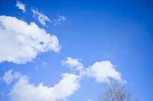 Blue sky with white clouds. Bright sunny day. Cumulus clouds high in the azure sky, beautiful view of the cloudy landscape. photo