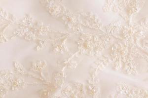 beige lace background with colors and bisser. beautiful delicate embroidery. delicate background texture. wedding lace. photo