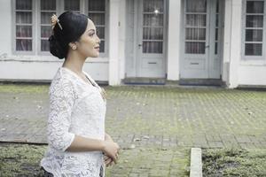 A young Indonesian woman with a happy successful expression wearing a white kebaya. Kartini's Day Concept. photo