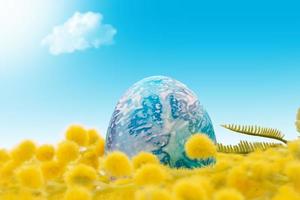 Painted blue egg in yellow mimosa on sunny sky background. Easter. Copy space