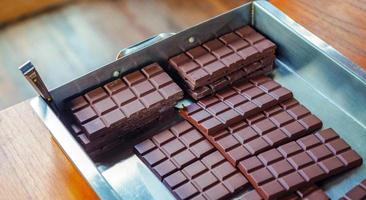 Homemade Fresh dark chocolate parts from the top view. close-up Chocolate bar and cocoa background photo