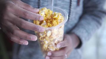 top visie van hand- Holding een kom van kleurrijk popcorn video