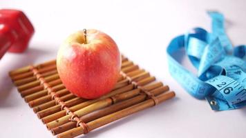 Measurement tape , apple and dumbbell on table video