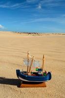 Toy boat in the sand photo