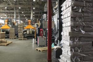 almacén de almacenamiento con productos empaquetados en palet de madera en la fábrica de papel reciclado. preparación envío de productos. instalación de logística, transporte y distribución para la entrega. cadena de suministro de carga foto