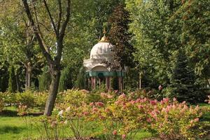 Trees and flowers in city park with Indian style lantern. Pedestrian zone for walking. Urban planning, public space concept. Town recreation area. Architecture design comfortable garden. Footpath way photo