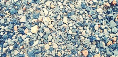 Pattern of small gravel, rock or stone on the ground for background in blue vintage color tone. Hard material, Art or Textured wallpaper and Group of object concept photo