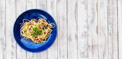 plano laico o parte superior ver espaguetis con almejas y seta rebanado o italiano Mariscos pasta y perejil en parte superior comida en azul plato en blanco grunge o áspero de madera antecedentes o mesa con Derecha Copiar espacio foto