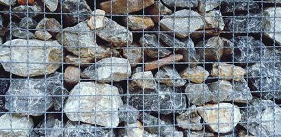 Many rock, stone or limestone in steel netting or net barrier for background in vintage tone. Group of object, Wallpaper and Hard material photo