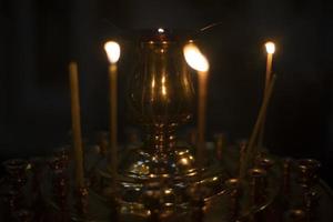 velas en templo. cera velas son incendio. religioso rito. detalles de fe. foto