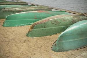 Old boats are overturned on shore. Boat station. Boats are drying up. photo