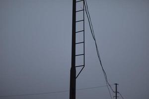 Wires on pole. Electrical wires on background of gray sky. Depressing look. photo