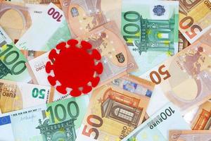 Red felt covid virus on 50 and 100 euro banknotes background. Coronavirus pandemic in Europe. Financial crisis, bank, money, economy, business concept. Place for text. photo