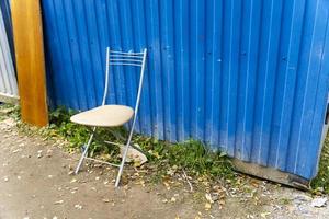 A furniture chair standing alone on the street along the buildings photo