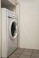 white washing machine in the corner of the bathroom, home life photo