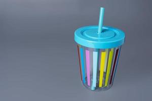 Colorful cheerful cup with a straw on a gray background photo