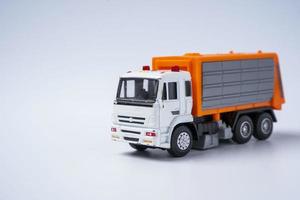 Toy car garbage truck with orange body, on a white background photo