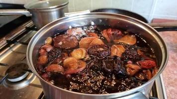 cuisine compote de séché poires et pommes dans une casserole sur une gaz poêle. le processus de bouillonnant, ébullition. cuit fruit. video