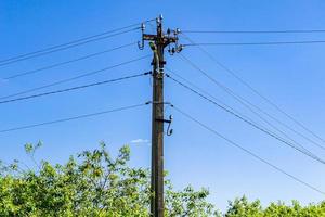 Power electric pole with line wire on colored background close up photo