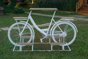 inventions to reduce global warming by bringing an old bicycle to design as a table with 2 seats in the middle as a table Placed on the lawn. Soft and selective focus. photo