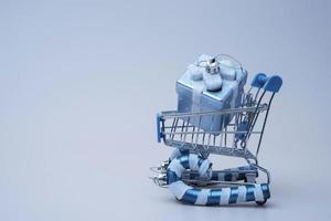 a supermarket trolley stylized as a sled carries boxes with gifts for Christmas photo