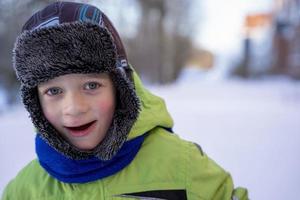 Funny Caucasian boy of 5 years old dressed in warm winter sports clothes photo