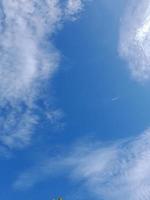 Beautiful white clouds on deep blue sky background. Large bright soft fluffy clouds are cover the entire blue sky. photo